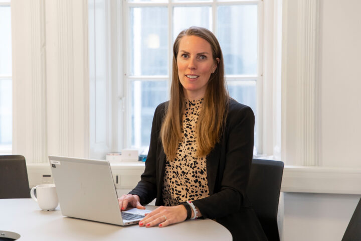 En rekryterare från SJR sitter framför en laptop i ett öppet kontorslandskap, redo att identifiera kandidater som matchar kundens behov med strukturerad och personlig approach.