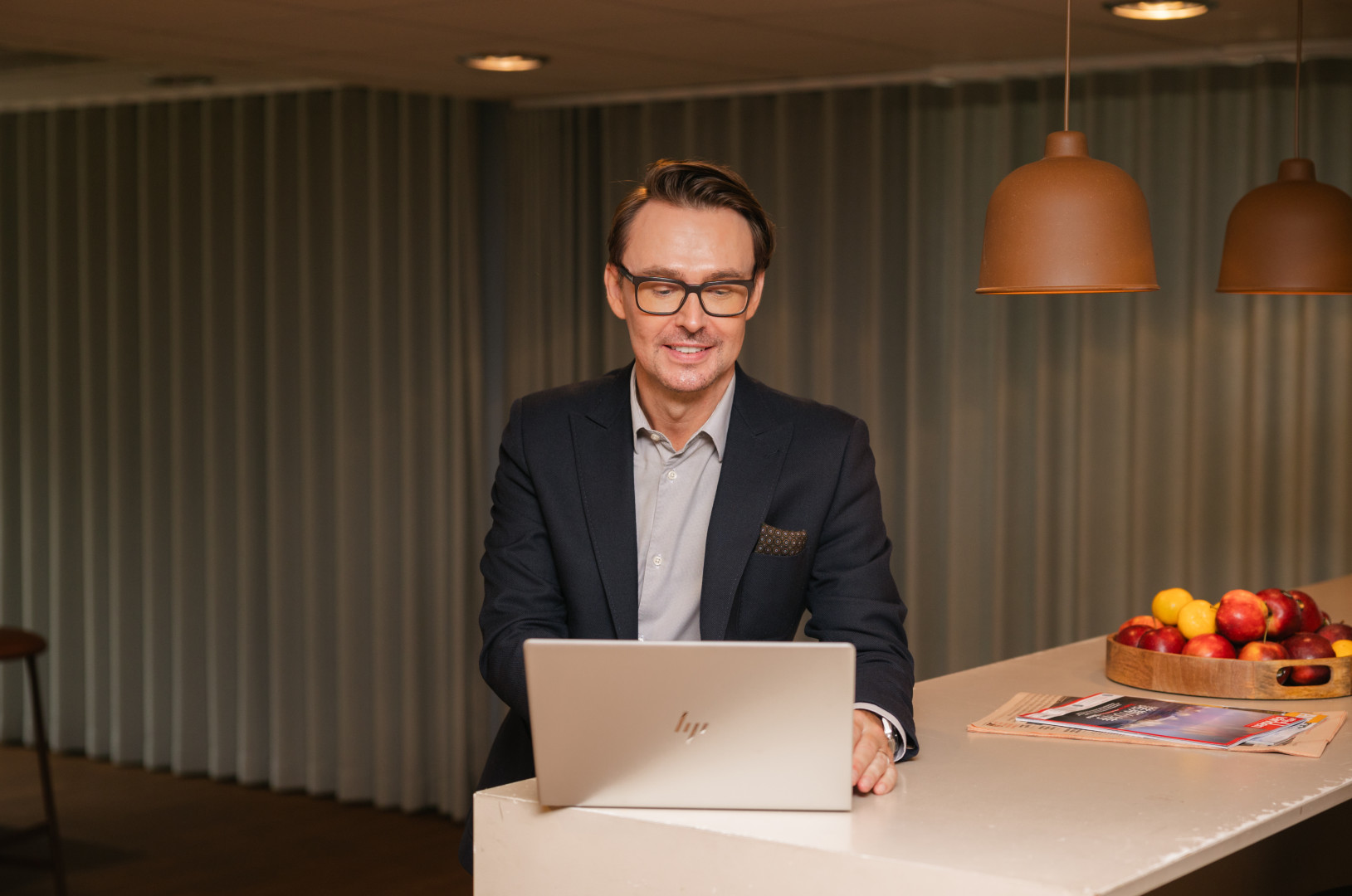 En man står vid ett högt bord och arbetar på sin laptop där SJR skapar en tillgänglig arbetsmiljö med fokus på flexibilitet och stöd.