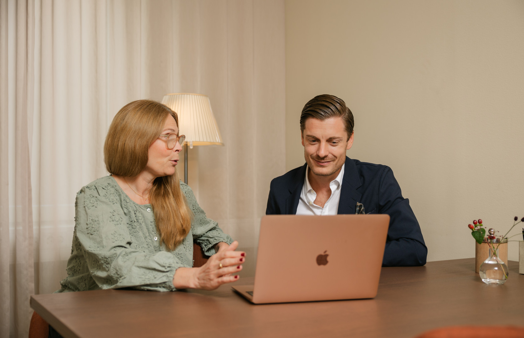 En man och en kvinna diskuterar vid en bärbar dator i ett dämpat kontor, där SJR möjliggör träffsäker kompetensmatchning genom erfarenhet, löpande dialog och moderna verktyg.