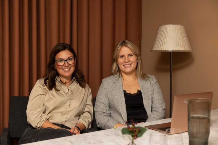 Två kvinnliga kollegor från SJR sitter sida vid sida med vänlig utstrålning, redo att presentera skräddarsydda lösningar för kundens kompetensbehov.