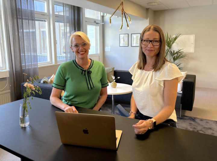Två kvinnliga kollegor från SJR sitter tillsammans framför en laptop i ett öppet och ljust kontor med vänlig utstrålning och identifierar lösningar för kundens kompetensbehov.