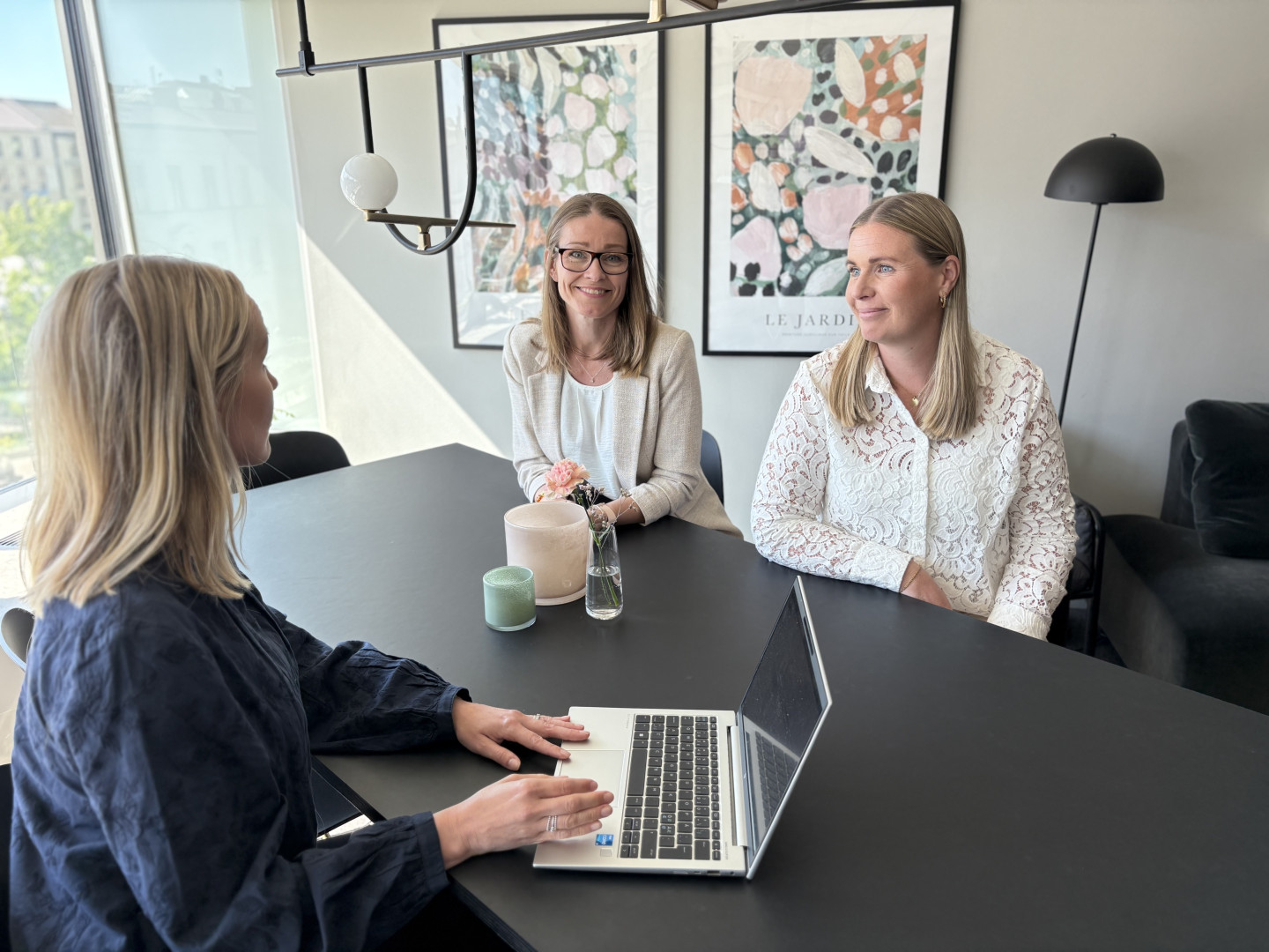 Ett samtal om kompetensbehov och konsultprofiler mellan tre kvinnliga kollegor från SJR vid ett bord i modernt öppet landskap med utsikt över centrala Göteborg.