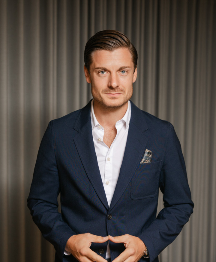 En porträttbild av en manlig kollega från SJR som står, klädd i kavaj och utstrålar professionalism och förtroendefulla relationer.